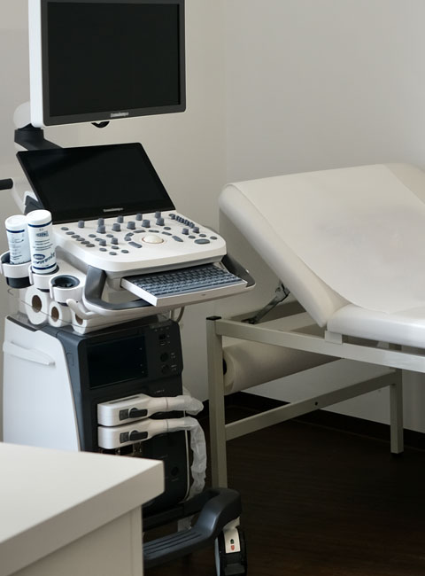 Sonografieraum mit Sonografiegerät und Ausschnitt Liege